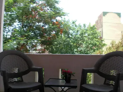two chairs and a table with flowers on a porch at El Fayrouz Hotel in Luxor