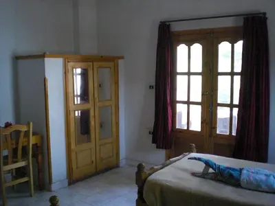 a bedroom with a bed and a wooden door at El Fayrouz Hotel in Luxor