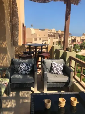 a patio with two chairs and a table on a balcony at Dar Om Ali ElGouna Sabina y160 2 14 in El Gouna