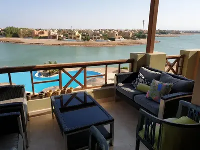 a balcony with a couch and a view of the water at Dar Om Ali ElGouna Sabina y160 2 14 in El Gouna