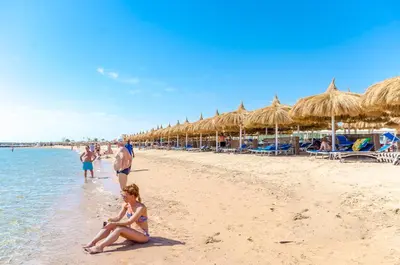 a group of people on a beach with umbrellas at Titanic Royal-Families and Couples only in Hurghada