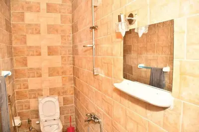 a bathroom with a toilet and a mirror at Om-Abdallah in Aswan