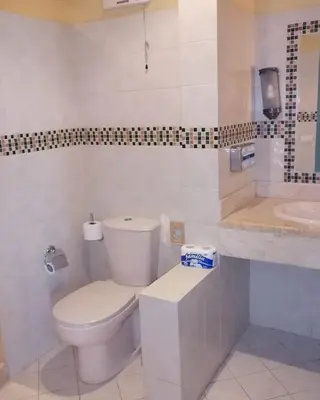 a white bathroom with a toilet and a sink at EL Gouna Abu tig Studio- Economy stay in Hurghada