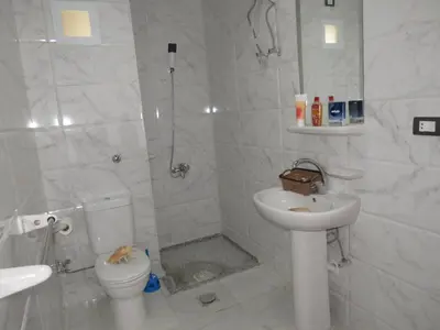 a white bathroom with a toilet and a sink at Apartment Bella Donna near the sea RedSeaLine. in Hurghada