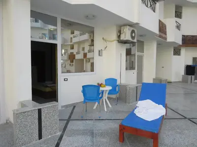 a patio with two blue chairs and a table at Apartment Bella Donna near the sea RedSeaLine. in Hurghada