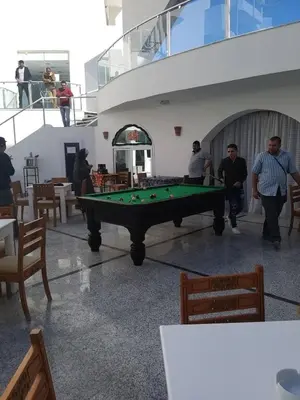 a group of people standing around a pool table at Apartment Bella Donna near the sea RedSeaLine. in Hurghada