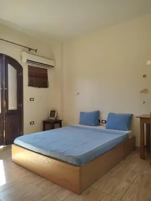 a bedroom with a large bed with blue sheets at Habibi Nubian Guest House-Nubian Hospitality in Aswan