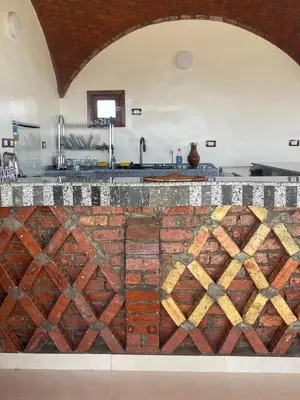 a kitchen with a brick counter top with at Habibi Nubian Guest House-Nubian Hospitality in Aswan