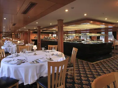 a restaurant with white tables and chairs and a bar at JAZ Imperial Nile Imperial Cruise - Every Thursday from Luxor- Aswan- Luxor for 07 Nights in Luxor