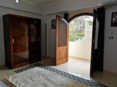 an open wooden door in a room with a rug at Luxor hotel Bella Vista Apartments and Hotel in Luxor