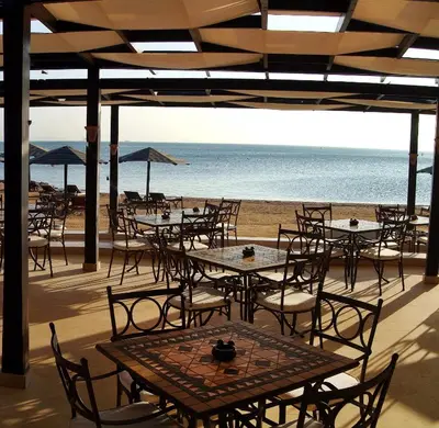 an empty patio with tables and chairs on the beach at Steigenberger Aqua Magic, All inclusive in Hurghada