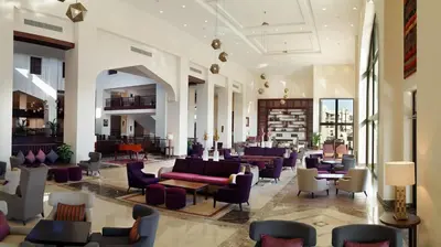 a lobby with couches and chairs in a building at Steigenberger Aqua Magic, All inclusive in Hurghada