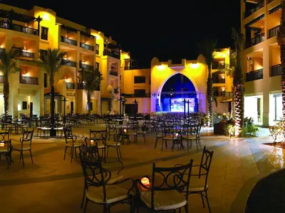 an empty courtyard with tables and chairs at night at Steigenberger Aqua Magic, All inclusive in Hurghada