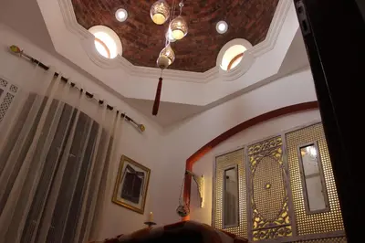 a living room with a ceiling with a chandelier at Beit Matta in Hurghada