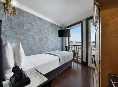 a hotel room with a bed and a balcony at Movenpick SS Misr Steamer Nile Cruise - 04 & 07 Nights Each Monday From Luxor and 03 Nights Each Friday from Aswan in Luxor