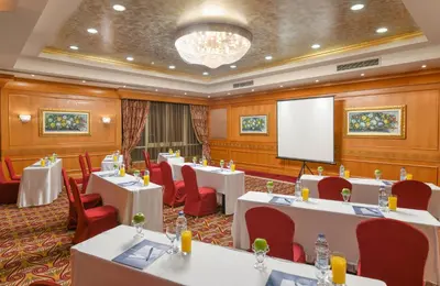 a conference room with tables and chairs and a screen at Tolip Aswan Hotel in Aswan