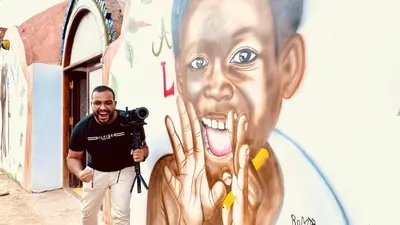 a man with a camera standing in front of a mural at Opal privat nubian hotel in Aswan
