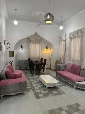 a living room with pink couches and a table at Alaa Aldin Flats in Luxor