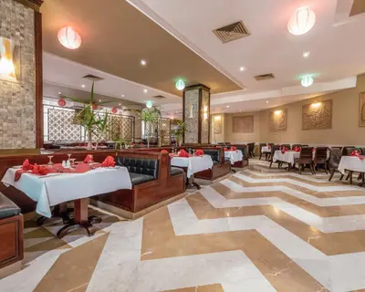a restaurant with tables and chairs and a large rug at AMC Royal Hotel & Spa in Hurghada