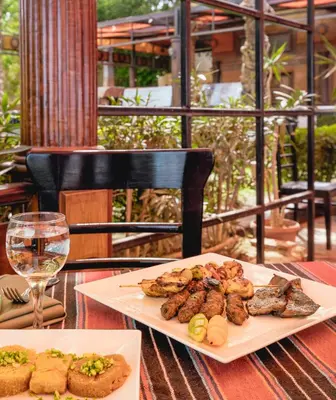a plate of food on a table with a glass of wine at AMC Royal Hotel & Spa in Hurghada