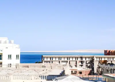 a view of a building with the ocean in the background at Marilyn Studio with Sea View Wi Fi in Hurghada