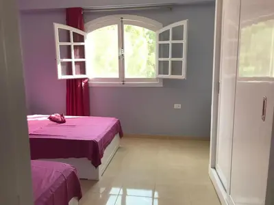 a bedroom with a bed and an open window at Hermina Guest House in Luxor
