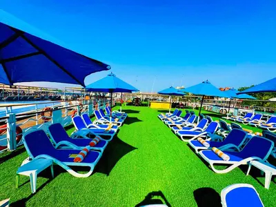 a row of blue chairs and umbrellas on a beach at MS Chateau Lafayette Nile Cruise - 4 nights from Luxor each Monday and 3 nights from Aswan each Friday in Luxor