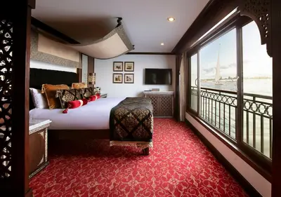 a hotel room with a bed and a large window at Dahabeya Yakouta Nile Cruise-Every Monday from Luxor- Aswan for 05 nights in Luxor