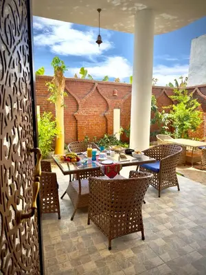 a patio with a table and chairs on a patio at Dar Lina Guesthouse Luxor in Luxor