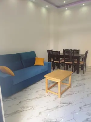 a living room with a blue couch and a table at Bravey Apartments in Hurghada