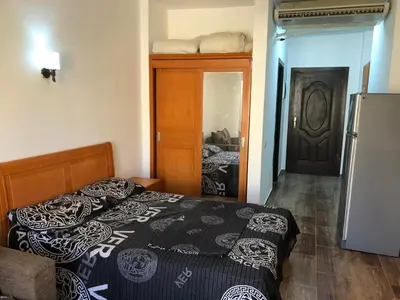 a small bedroom with a bed and a refrigerator at Studio Florenza Khamsin in Hurghada