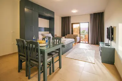 a dining room with a table and a living room at BeachView Turtles in Hurghada
