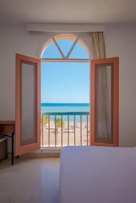 a bedroom with a large window with a view of the beach at VESTA - El Gouna Residence in Hurghada