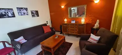 a living room with a couch and chairs and a mirror at Senmut Luxory Apartments in Luxor