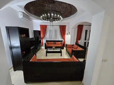 a living room with a couch and a chandelier at Villa - Sleeps 6 - Heated Pool - Garden - Parking in Hurghada