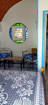 a room with a bed and two chairs and a window at Nuba Tod Abouda Guest House in Aswan