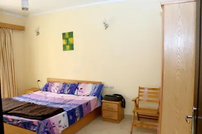 a bedroom with a bed and a chair in it at Apartment F in Florenza Khamsin in Hurghada