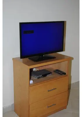 a tv sitting on top of a wooden entertainment center at Apartment G in Florenza Khamsin in Hurghada