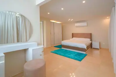 a small bedroom with a bed and a mirror at Arena Beach Resort & premium suits in Hurghada