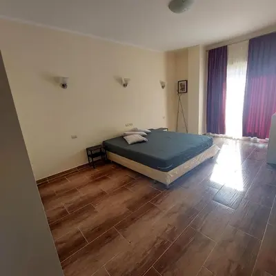 a bedroom with a bed and a wooden floor at Florenza Khamsin 1 bedroom apartment with swimming pool view in Hurghada