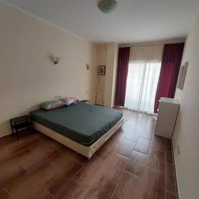 a bedroom with a bed and a wooden floor at Florenza Khamsin 1 bedroom apartment with swimming pool view in Hurghada