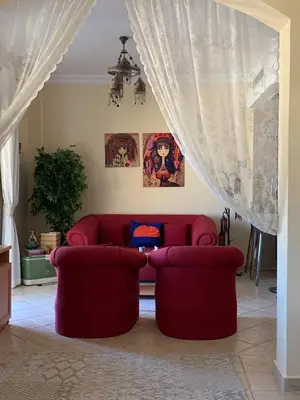 a living room with a red couch and two chairs at Beachfront Cozy One Bedroom apartment Sahl Hasheesh Palma de Piazza in Hurghada