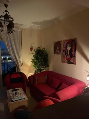 a living room with a red couch and a table at Beachfront Cozy One Bedroom apartment Sahl Hasheesh Palma de Piazza in Hurghada