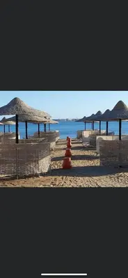 a beach with some umbrellas and the ocean at Beachfront Cozy One Bedroom apartment Sahl Hasheesh Palma de Piazza in Hurghada