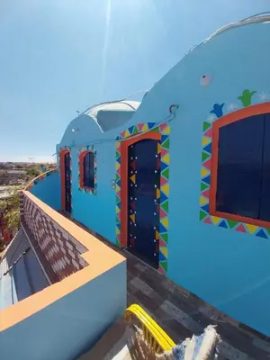 a blue house with a colorful door and window at NeNeKaTo Nubian House in Aswan