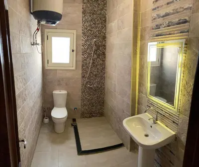 a small bathroom with a toilet and a sink at Bahga Palace 4 Residential Apartments in Hurghada
