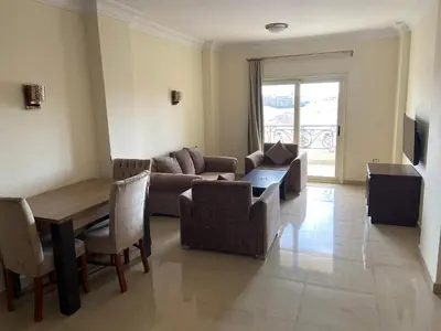 a living room with a couch and a table and chairs at Bahga Palace 5 Residential Apartments in Hurghada