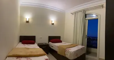a room with two beds and a window with a view at Bahga Palace 5 Residential Apartments in Hurghada