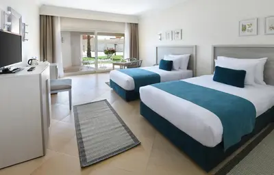 a hotel room with two beds and a television at JAZ Soma Beach in Hurghada