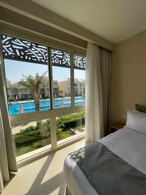 a bedroom with a bed and a large window at Mangroovy Residence El Gouna - Grovin in Hurghada